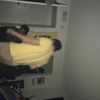 a man in a yellow shirt is playing wii in a room